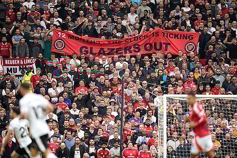 English Premier League 2024-25 Liverpool vs Manchester United: A banner writing ' Glazers out' is displayed by spectators during the match